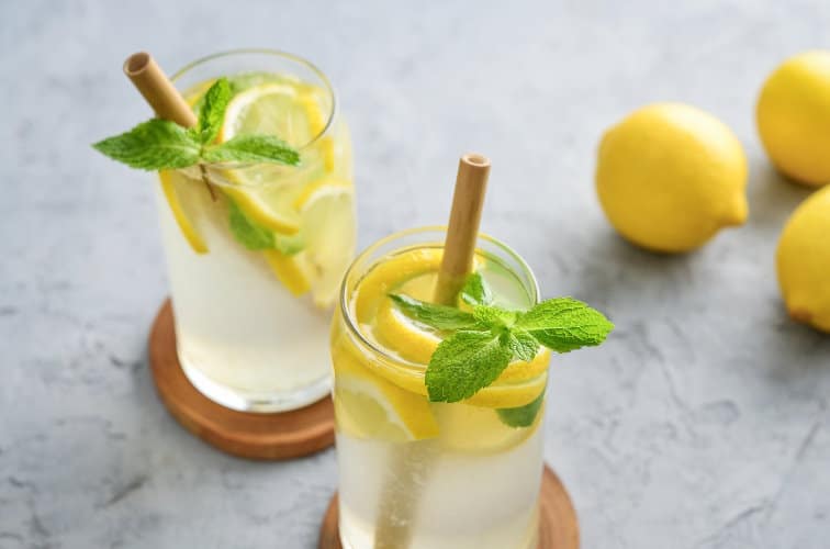 Limoncello Spritz Cocktails mit frischen Zitronenscheiben und Minze
